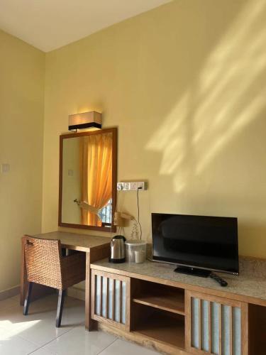 a living room with a tv and a mirror at Studio 7 Gold Coast Morib Resort in Banting