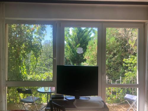 a computer monitor sitting on a desk in front of two windows at Apartman-Donau Tát in Tát