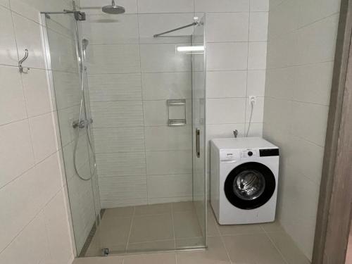 uma cabina de duche com uma máquina de lavar roupa na casa de banho em Apartmán Košice em Košice