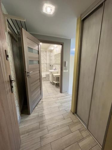 a hallway of a bathroom with a door and a sink at Apartament COMFORT Centrum in Krotoszyn