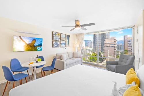 a living room with a table and chairs and a large window at Newly Renovated Ilikai Marina Studio - Near Beach! in Honolulu