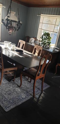 a dining room table and chairs in a room with a window at Søberget in Stange
