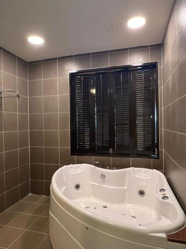 a bath tub in a bathroom with a window at Studio 6 Gold Coast Morib Resort in Banting