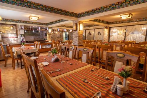 un restaurante con una mesa larga y sillas en Little Tibet, en Darjeeling