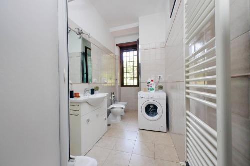 a white bathroom with a washing machine in it at Vatican Flat Cozy with Private Court in Rome