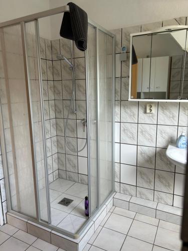 a shower with a glass door in a bathroom at FeWo Beim Museumsdorf in Buchholz in der Nordheide