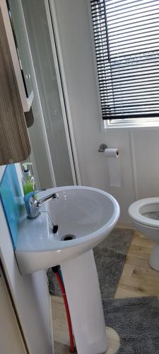 a bathroom with a white sink and a toilet at Sailor's Corner in Prestatyn