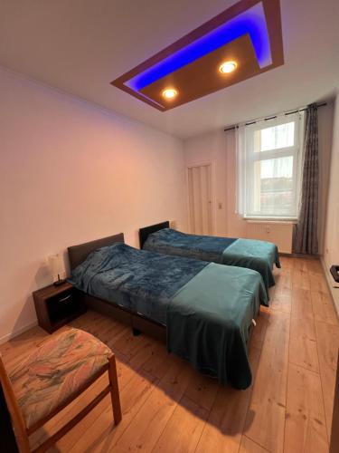 a bedroom with two beds and a blue light at Gera Apartment in Gera