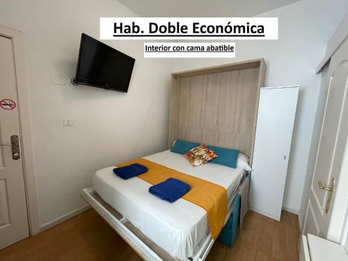 a small bedroom with a bed with a tv on the wall at El Sueño De Alejandra - Apartments in Las Palmas de Gran Canaria