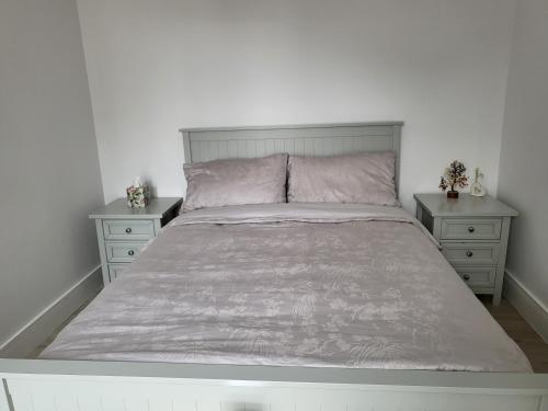 a white bedroom with a bed and two night stands at Bright, quiet room in the center of Newbury in Newbury