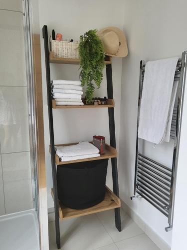 a shelf in a bathroom with towels and a shower at Bright, quiet room in the center of Newbury in Newbury