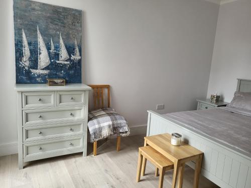 a bedroom with a bed and a dresser and a table at Bright, quiet room in the center of Newbury in Newbury