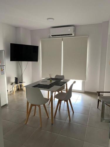 - une salle à manger avec une table, des chaises et une télévision dans l'établissement Departamento D, à Bahía Blanca