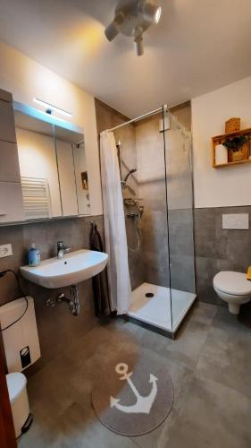 a bathroom with a shower and a sink and a toilet at Fewo Am Deich 1 Appartment 30 in Sankt Peter-Ording