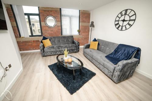 ein Wohnzimmer mit einem Sofa und einem Tisch in der Unterkunft Bv Luxury Apartment Conditioning House in Bradford