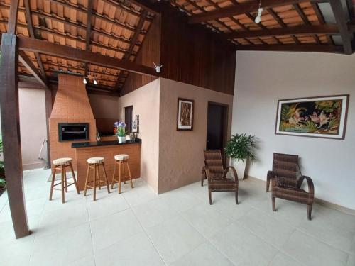 a living room with chairs and a kitchen with a stove at Casa Itoupava Norte in Blumenau