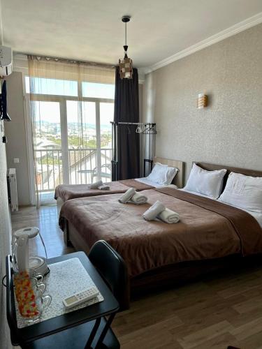 a hotel room with two beds and a table at Hotel Marioni in Tbilisi City