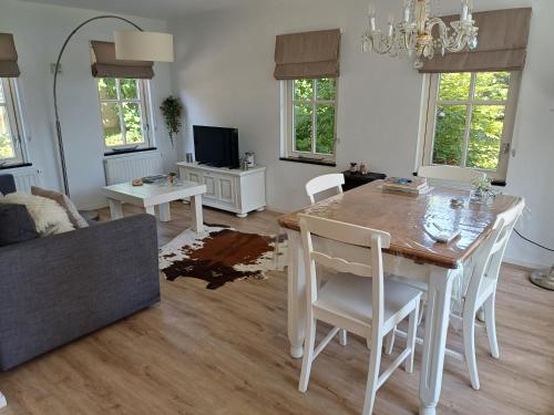 a living room with a dining room table and a couch at B&B Het mooie uitzicht in Reuver