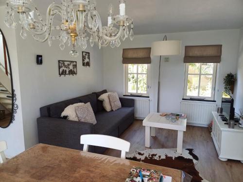 a living room with a couch and a chandelier at B&B Het mooie uitzicht in Reuver