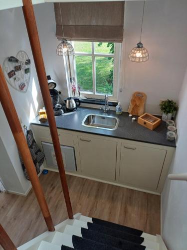 a kitchen with a sink and a window at B&B Het mooie uitzicht in Reuver