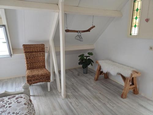 a living room with a staircase and a chair at B&B Het mooie uitzicht in Reuver