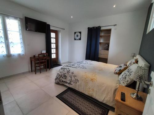een slaapkamer met een bed, een bureau en een raam bij Maison pour 4/ 6 personnes les hirondelles in Saint-Vivien-de-Monségur