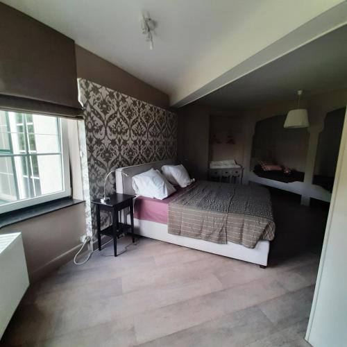 um pequeno quarto com uma cama e uma janela em Huize tinke em Tongeren