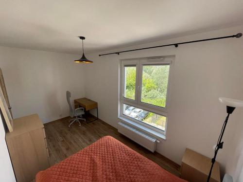 a bedroom with a large window and a red rug at Airport Warsaw Mokotow Luxury Apartment in Warsaw