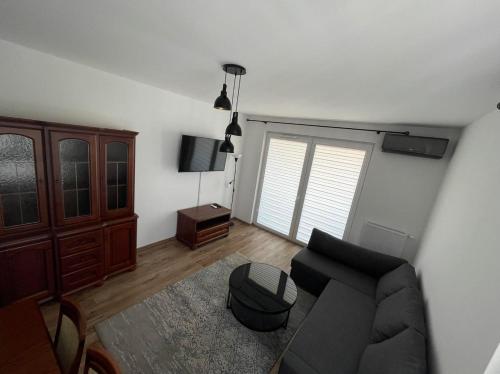 a living room with a couch and a tv at Airport Warsaw Mokotow Luxury Apartment in Warsaw