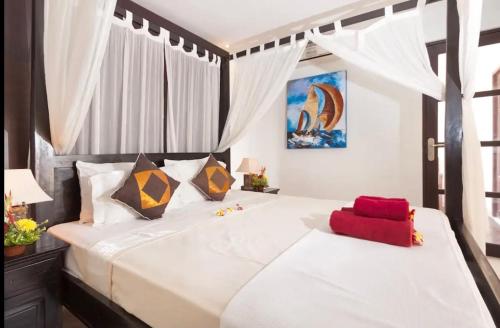 a bedroom with two large white beds with curtains at Villa Kubu Pratiwi - Villa 2 in Canggu