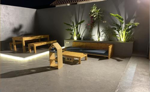 una camera con panche in legno e piante in vaso di أكواخ البحيرات a Khalij Salman