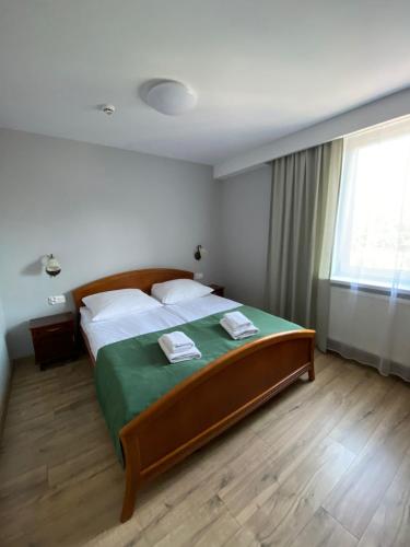 a bedroom with a large bed with two towels on it at Hotel Kresowianka in Konin