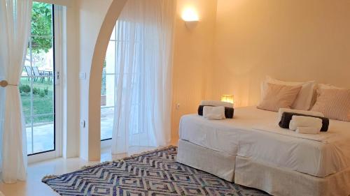 a bedroom with a bed and a large window at Nama Beach House in rkadiko Chorio