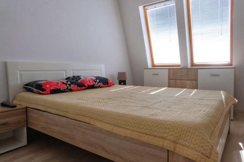 a bedroom with a large bed with two windows at Cosy apartment in Kumanovo in Kumanovo