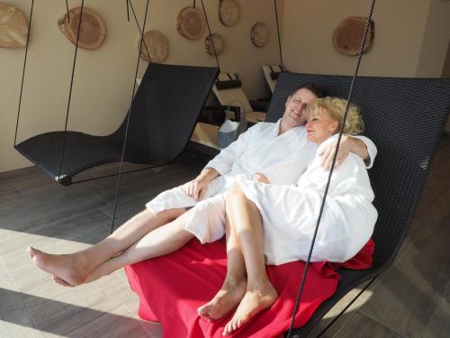 a man and woman sitting on a swing at Landrefugium Obermüller 4,5 Sterne in Untergriesbach