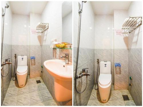 a bathroom with two toilets and a sink and a shower at Hùng Thư Motel in Da Nang