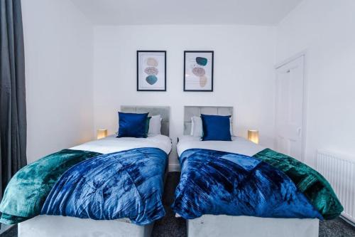 2 letti con cuscini bianchi e blu in una stanza di Luxurious Living 2 BR Home MCR a Manchester