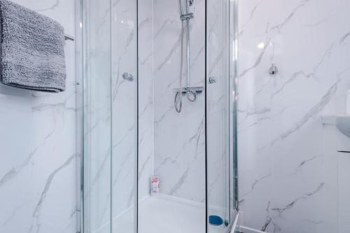 a bathroom with a shower with a glass door at Luxurious Living 2 BR Home MCR in Manchester
