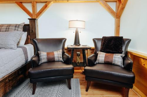 two chairs in a bedroom with a bed and a lamp at Battenkill Glamping Resort in Cambridge