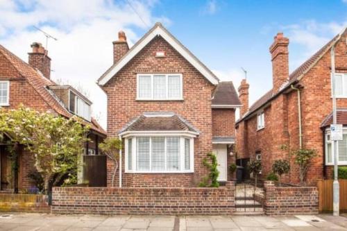 a brick house with a brick fence in front of it at Cheerful 3 bedroom house with generous rear garden in Kent