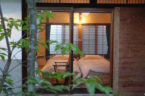 Hostel Fish in a River في تاكاياما: غرفة نوم صغيرة مع سرير في غرفة