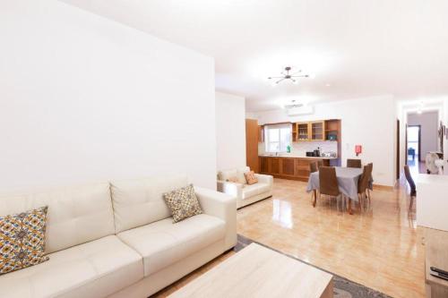 uma sala de estar com um sofá branco e uma sala de jantar em Gudja - Lovely 3 bedroom unit with own private entrance em Gudja