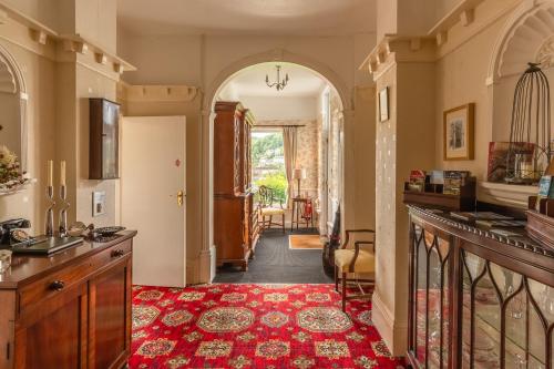 a hallway of a home with a red rug at Rockvale House in Lynton