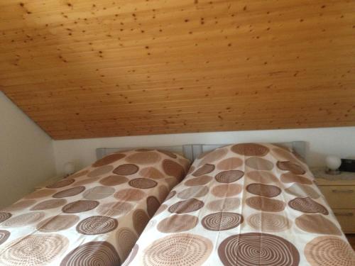 a bed in a room with a wooden ceiling at Wunderschöne Ferienwohnung im Haus Schupp mit bester Aussicht in Wittenschwand