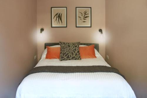 a bedroom with a large bed with orange pillows at Knightstone Apartment in Weston-super-Mare