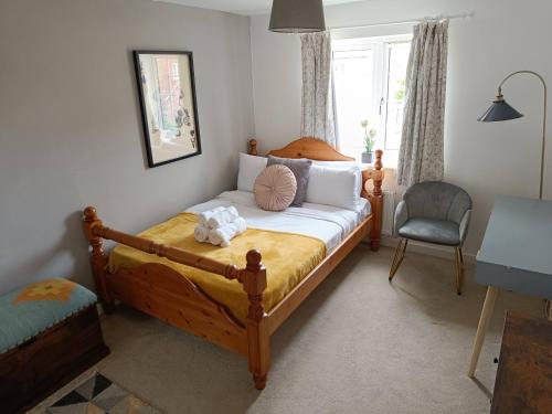 a bedroom with a bed and a chair and a window at 3 bedroom townhouse near Bicester Village in Bicester