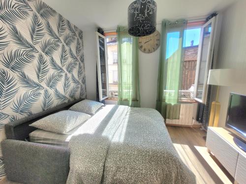 Un dormitorio con una cama, un sofá y un televisor. en Le Paséo, en Troyes