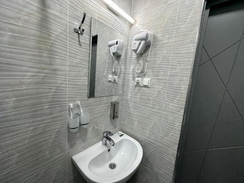 a bathroom with a sink and a mirror at Byond Hotel & Hostel in Tashkent