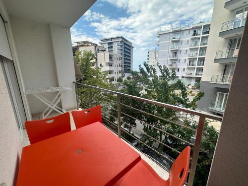 a red bench on the balcony of a building at Apartment Rrihnaj in Shëngjin