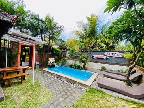 eine Villa mit einem Pool und einem Picknicktisch in der Unterkunft Uma Dewa homestay in Keramas